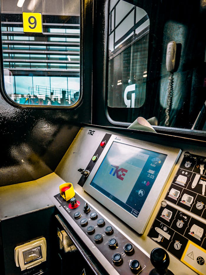 View of a modern control panel inside an industrial vehicle at a station with a yellow sign indicating number 9.